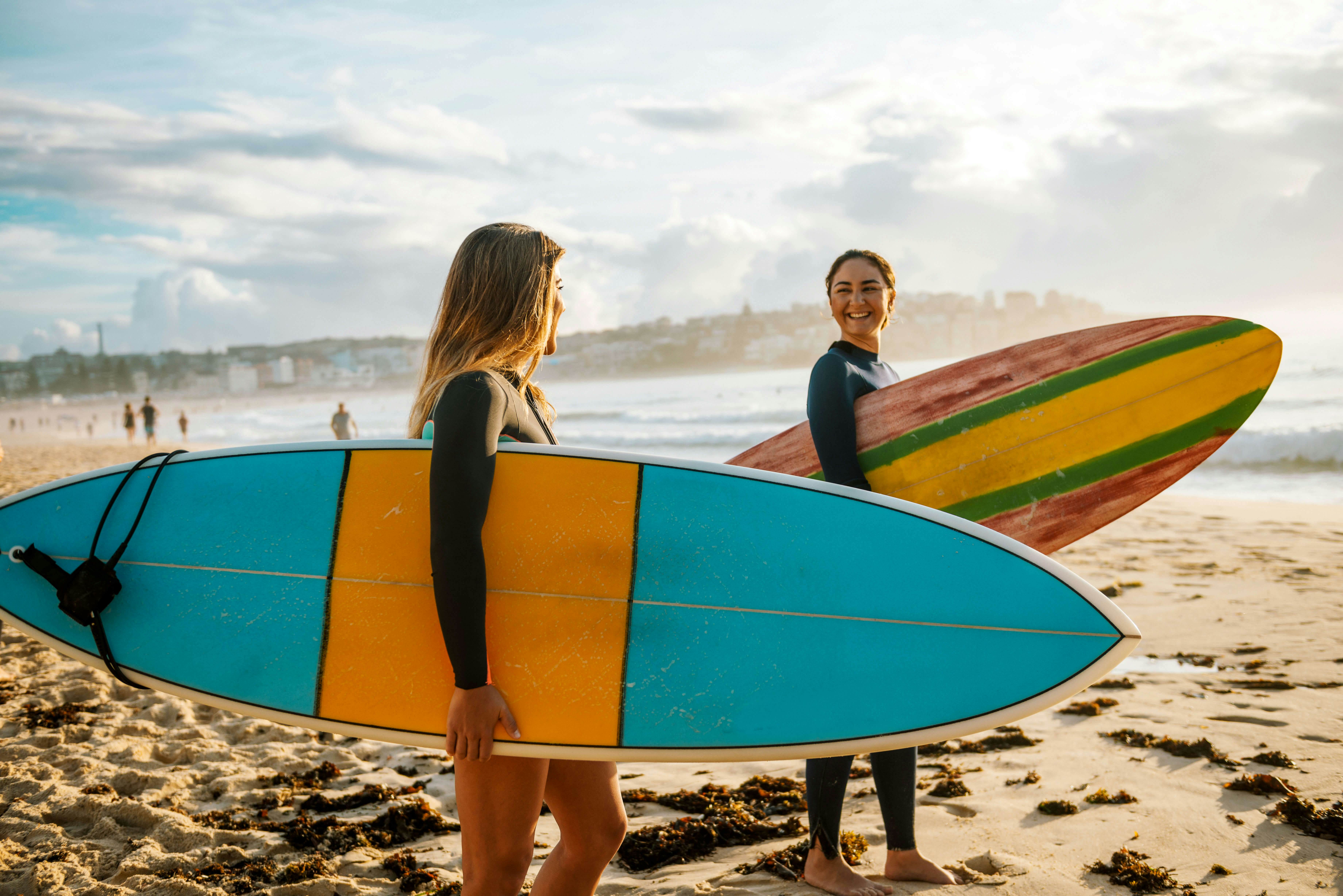 Two female friends with surfboards.